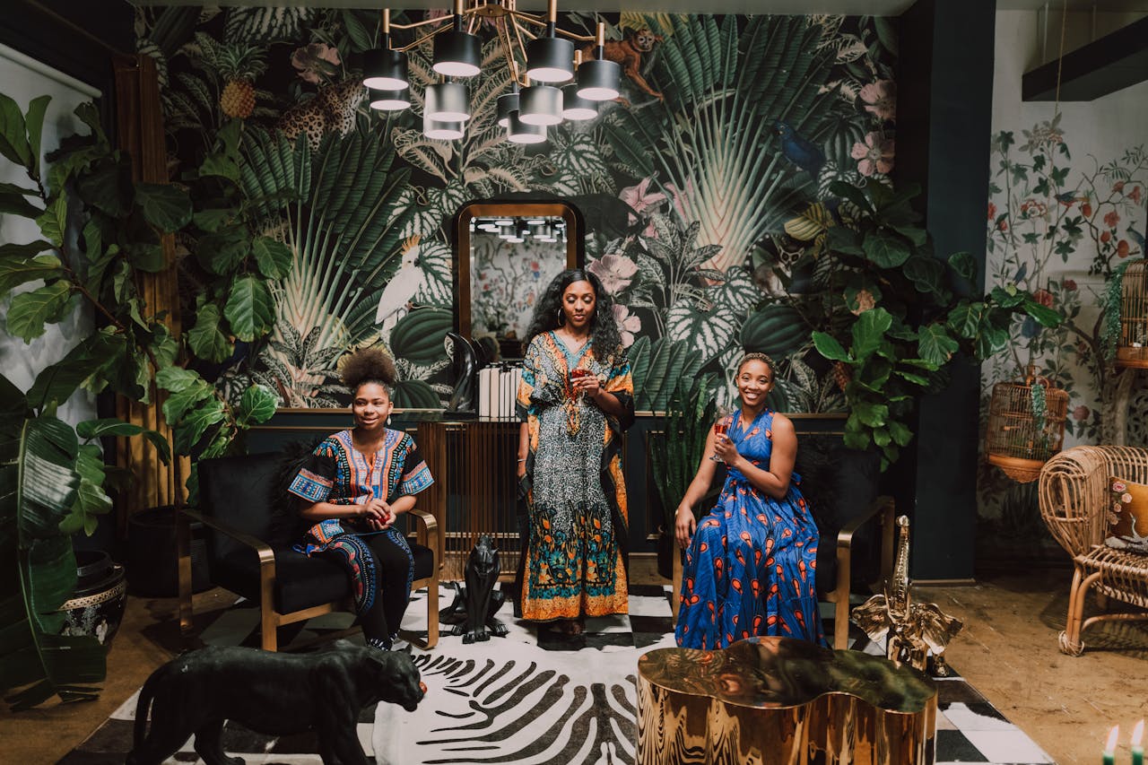 gallery-2 Three African women in traditional attire celebrating indoors with vibrant decor