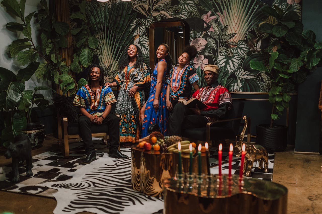 gallery-3 Group celebrating Kwanzaa with traditional clothes and candles indoors.