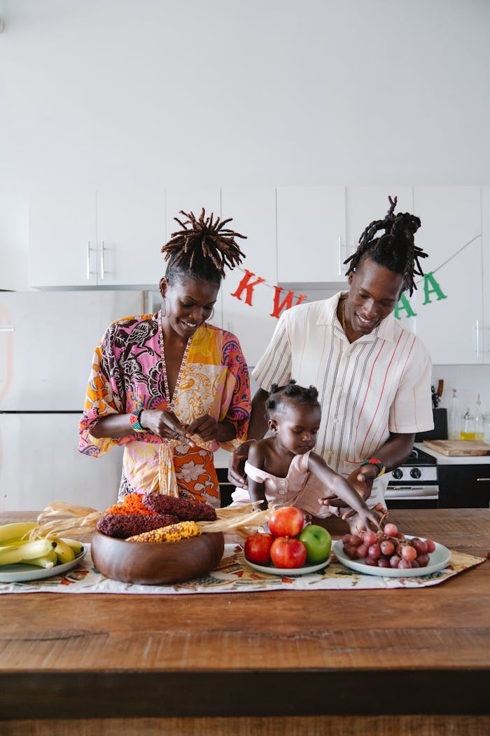 gallery-1 Family preparing fruits and traditional food for Kwanzaa celebration in a modern kitchen.